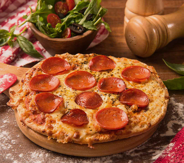 Pizza de pepperoni con ensalada fresca