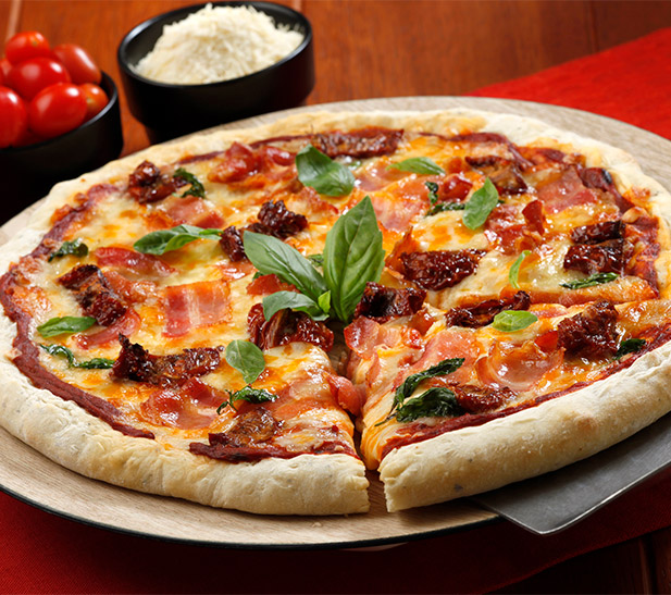 Pizza de tocineta ahumada con albahaca y tomates secos